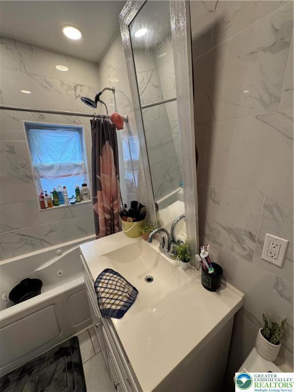 640 Park St, Allentown City, PA 18102 - full bath featuring vanity, tile walls, and shower / tub combo with curtain