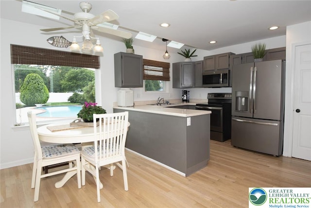 1325 Devon Cir S, Whitehall Twp, PA 18104 - kitchen with appliances with stainless steel finishes, a peninsula, light wood finished floors, light countertops, and a ceiling fan