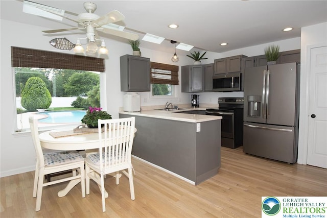 1325 Devon Cir S, Whitehall Twp, PA 18104 - kitchen featuring appliances with stainless steel finishes, a peninsula, light wood-style floors, ceiling fan, and light countertops