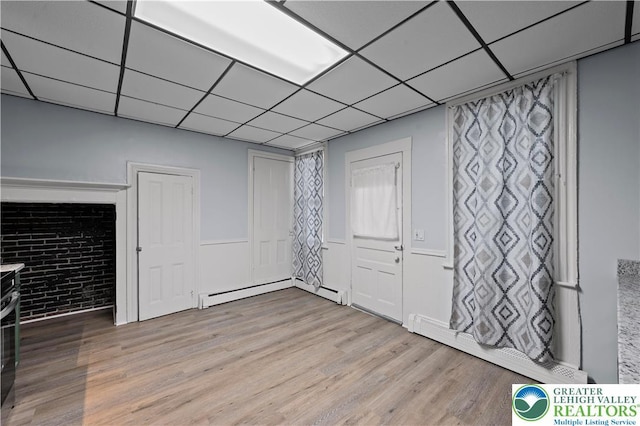 919 Lehigh St, Easton, PA 18042 - unfurnished living room featuring baseboard heating, wood finished floors, and a drop ceiling