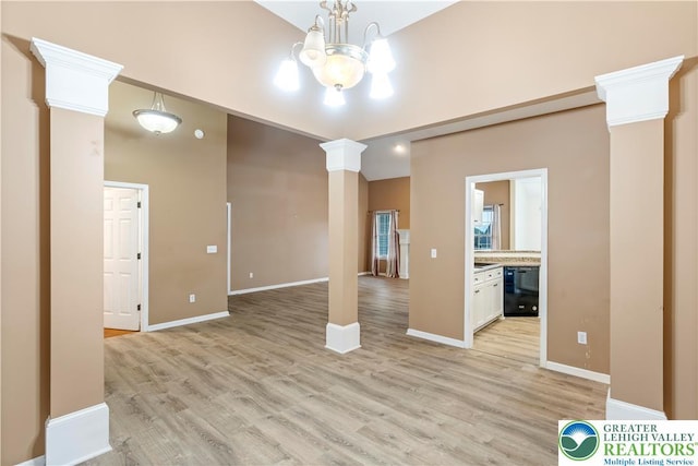 620 Pittston Ave, Luzerne, PA 18641 - spare room featuring ornate columns, light wood-type flooring, and a chandelier