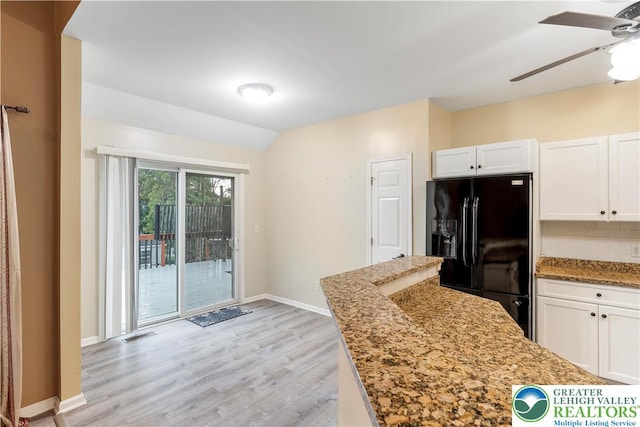 620 Pittston Ave, Luzerne, PA 18641 - kitchen with black fridge, light wood-style floors, white cabinets, ceiling fan, and light stone countertops