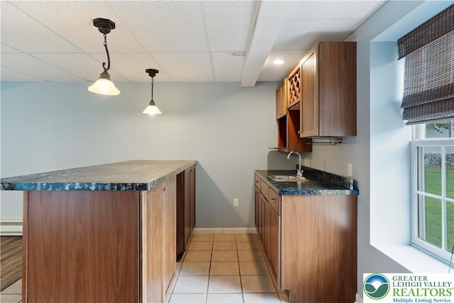 620 Pittston Ave, Luzerne, PA 18641 - kitchen with dark countertops, a peninsula, light tile patterned flooring, a drop ceiling, and decorative light fixtures