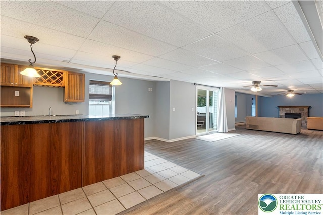 620 Pittston Ave, Luzerne, PA 18641 - kitchen with a drop ceiling, wood finished floors, plenty of natural light, a ceiling fan, and a tile fireplace