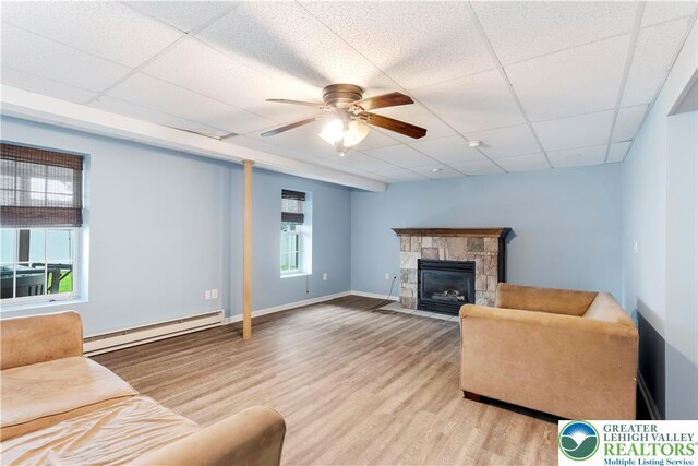 620 Pittston Ave, Luzerne, PA 18641 - living room featuring baseboard heating, plenty of natural light, a drop ceiling, and wood finished floors