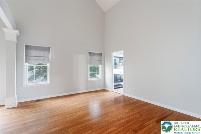 620 Pittston Ave, Luzerne, PA 18641 - spare room featuring ornate columns, plenty of natural light, high vaulted ceiling, and wood finished floors