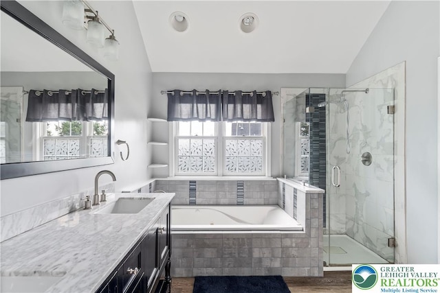 620 Pittston Ave, Luzerne, PA 18641 - bathroom with lofted ceiling, a garden tub, a shower stall, vanity, and wood finished floors
