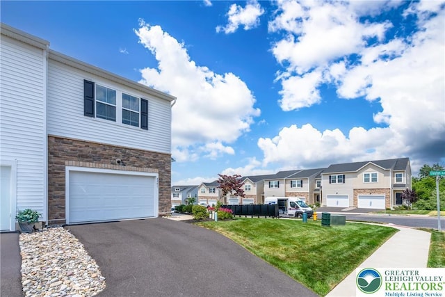 4901 Brookside Ct, Upper Saucon Twp, PA 18036 - view of front of house featuring stone siding, a residential view, an attached garage, and a front yard