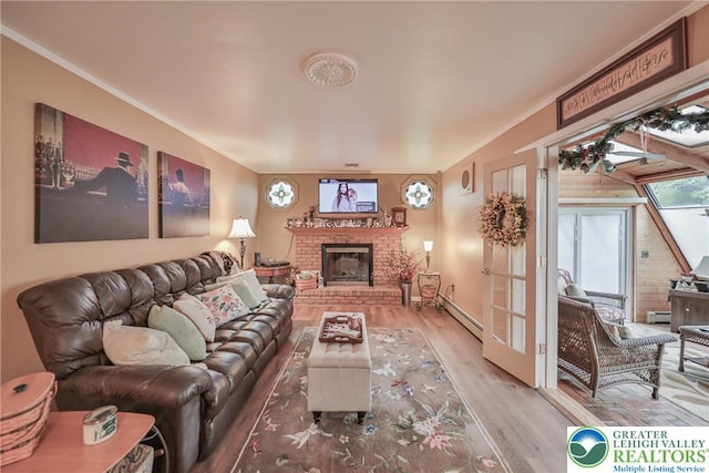 1812 Treeline Dr, Forks Twp, PA 18040 - living area featuring wood finished floors, a brick fireplace, a baseboard radiator, baseboard heating, and crown molding