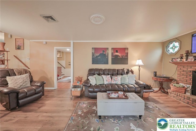 1812 Treeline Dr, Forks Twp, PA 18040 - living room featuring wood finished floors, crown molding, stairs, and a brick fireplace