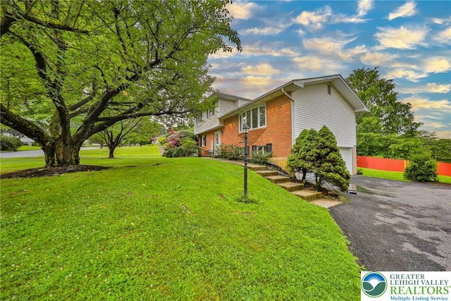 1812 Treeline Dr, Forks Twp, PA 18040 - view of home's exterior featuring a lawn, asphalt driveway, brick siding, and an attached garage