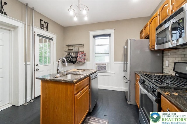 537 Seitz St, Easton, PA 18042 - kitchen featuring appliances with stainless steel finishes, brown cabinets, healthy amount of natural light, wainscoting, and a kitchen island with sink