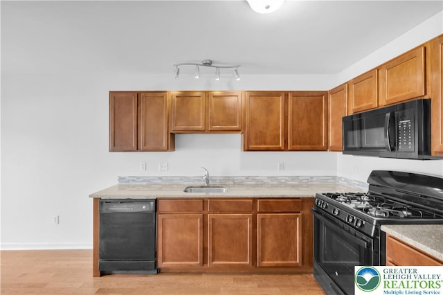 733 Trout Creek Ln, Allentown City, PA 18103 - kitchen featuring black appliances, light wood finished floors, and brown cabinetry