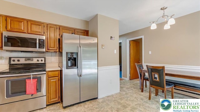 671 Dotters Corner Rd, Polk Twp, PA 18058 - kitchen featuring appliances with stainless steel finishes, a baseboard radiator, a chandelier, and brown cabinets