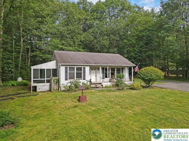 671 Dotters Corner Rd, Polk Twp, PA 18058 - view of front of house featuring a porch, a front yard, a sunroom, and a shingled roof