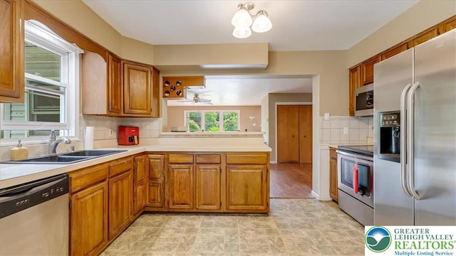 671 Dotters Corner Rd, Polk Twp, PA 18058 - kitchen featuring appliances with stainless steel finishes, brown cabinetry, light countertops, backsplash, and a ceiling fan