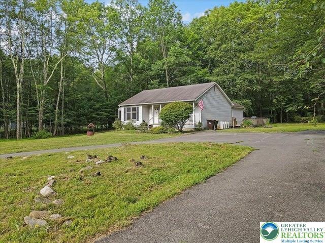 671 Dotters Corner Rd, Polk Twp, PA 18058 - view of front of house with asphalt driveway, a front lawn, and a view of trees