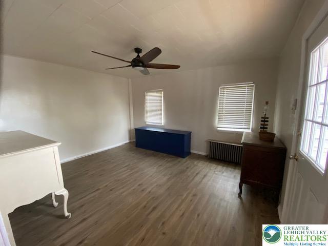 838 E Patterson St, Lansford Boro, PA 18232 - unfurnished living room featuring radiator heating unit, wood finished floors, and healthy amount of natural light