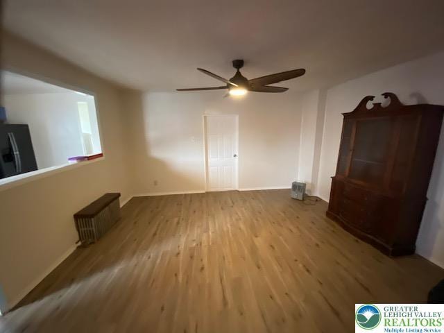 838 E Patterson St, Lansford Boro, PA 18232 - unfurnished bedroom featuring black refrigerator with ice dispenser, radiator, wood finished floors, and a ceiling fan