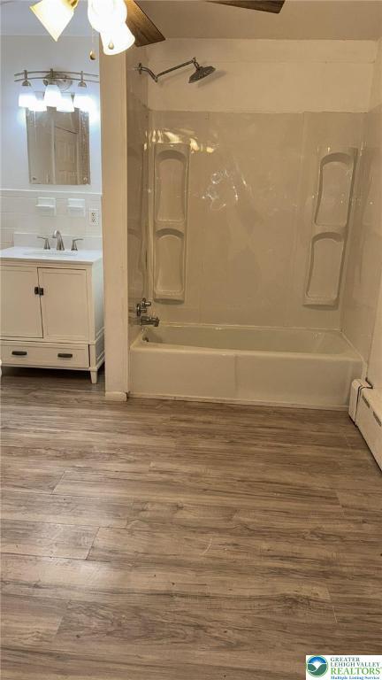 838 E Patterson St, Lansford Boro, PA 18232 - full bathroom featuring bathtub / shower combination, wood finished floors, vanity, ceiling fan, and a baseboard radiator