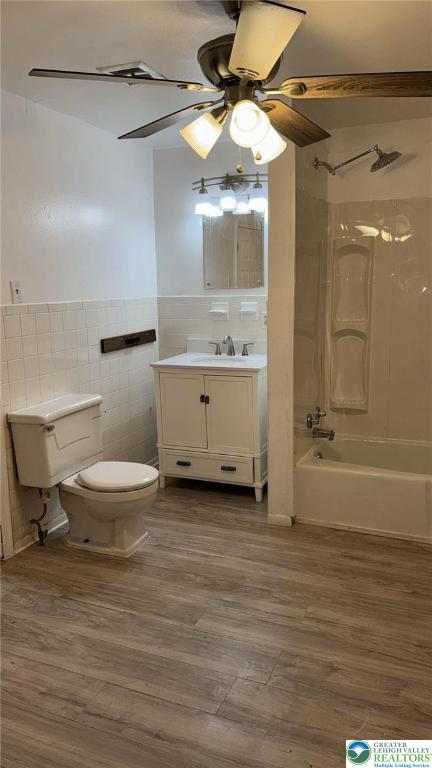 838 E Patterson St, Lansford Boro, PA 18232 - full bathroom with tile walls, ceiling fan, vanity, shower / tub combination, and wood finished floors