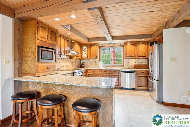 6365 Constitution Rd, Lowhill Twp, PA 18078 - kitchen with stainless steel appliances, a peninsula, under cabinet range hood, a wood ceiling with exposed beams, and brown cabinetry