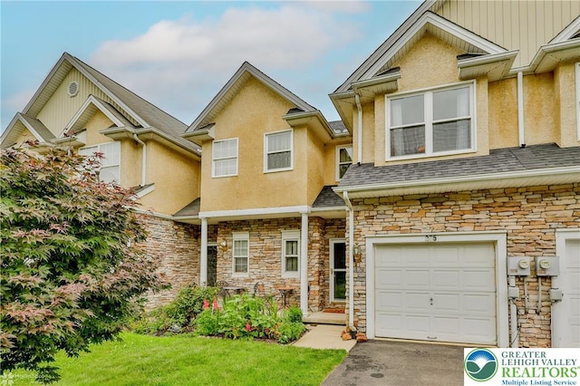 205 Maple Ct, Alburtis Boro, PA 18011 - townhome / multi-family property featuring stone siding, stucco siding, an attached garage, a front yard, and asphalt driveway
