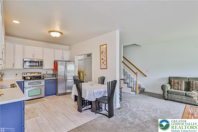 205 Maple Ct, Alburtis Boro, PA 18011 - kitchen featuring stainless steel appliances, light countertops, white cabinetry, and blue cabinetry