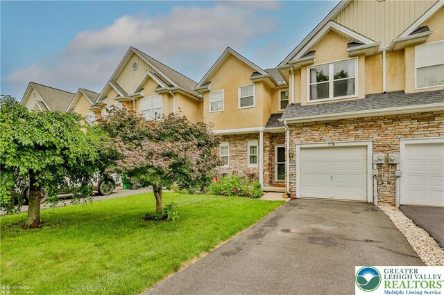 205 Maple Ct, Alburtis Boro, PA 18011 - townhome / multi-family property featuring stone siding, a front lawn, driveway, and stucco siding
