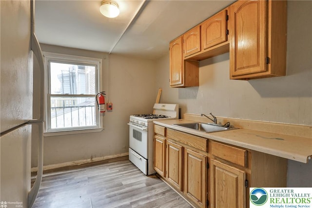 209 Cattell St, Easton, PA 18042 - kitchen with white appliances, light wood finished floors, light countertops, and brown cabinetry