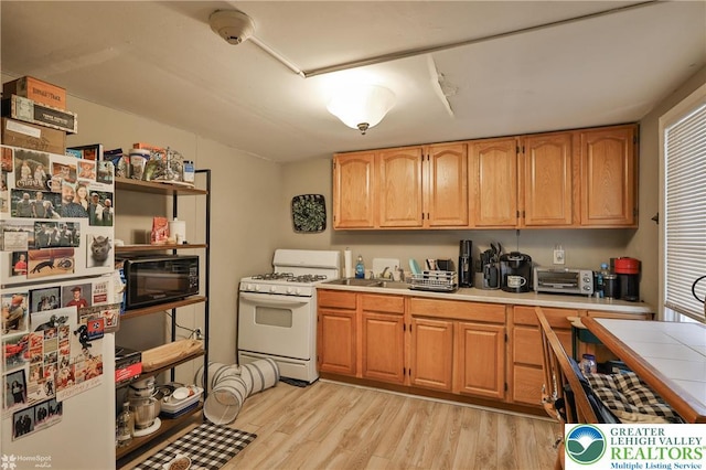 209 Cattell St, Easton, PA 18042 - kitchen featuring white appliances, light wood-style floors, and tile countertops