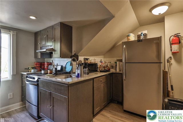 209 Cattell St, Easton, PA 18042 - kitchen featuring appliances with stainless steel finishes, under cabinet range hood, light wood-style floors, light stone counters, and dark brown cabinetry
