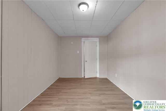 409 Broad St Unit 409, Tamaqua Boro, PA 18252 - empty room featuring light wood finished floors, a paneled ceiling, and wooden walls