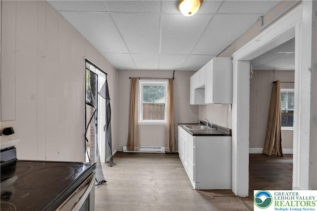 409 Broad St Unit 409, Tamaqua Boro, PA 18252 - kitchen with a paneled ceiling, a baseboard radiator, white cabinets, light wood-style floors, and electric range