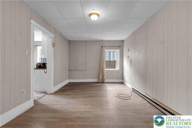 409 Broad St Unit 409, Tamaqua Boro, PA 18252 - empty room with wood finished floors, baseboard heating, wood walls, and a paneled ceiling
