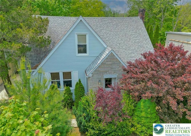 717 Claremont Ave, Schuylkill, PA 18252 - view of front facade featuring stone siding, a chimney, and roof with shingles