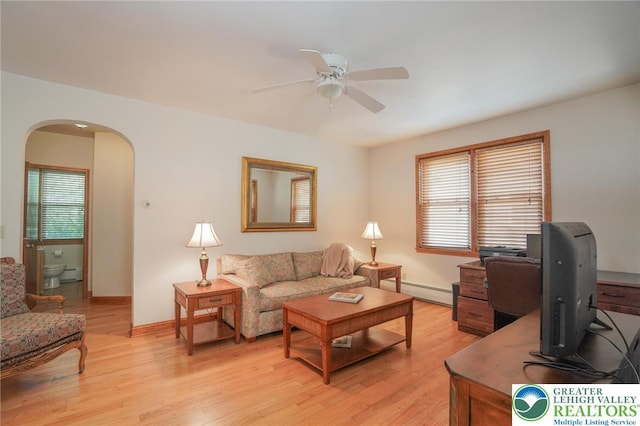 717 Claremont Ave, Schuylkill, PA 18252 - living room featuring arched walkways, a ceiling fan, a baseboard heating unit, and light wood finished floors