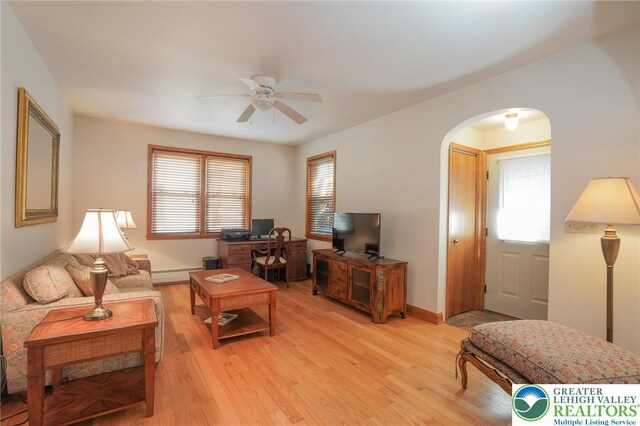 717 Claremont Ave, Schuylkill, PA 18252 - living room featuring a baseboard heating unit, arched walkways, ceiling fan, and plenty of natural light
