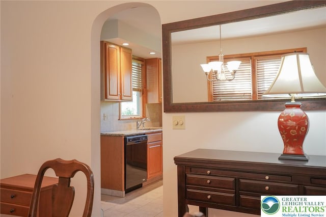 717 Claremont Ave, Schuylkill, PA 18252 - kitchen with dishwasher, decorative backsplash, arched walkways, light tile patterned floors, and a chandelier