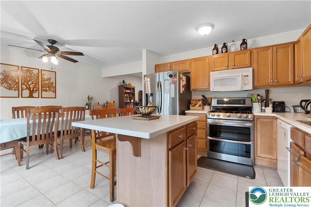 8067 Heritage Dr, Lower Macungie Twp, PA 18011 - kitchen featuring stainless steel appliances, light countertops, light tile patterned floors, and a ceiling fan