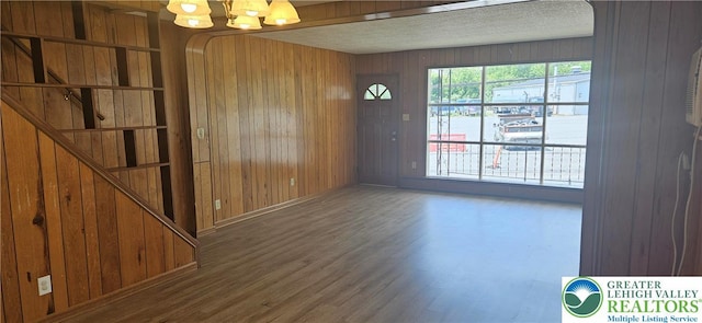 455 W Church St, Slatington Boro, PA 18080 - unfurnished dining area featuring wooden walls, wood finished floors, a textured ceiling, a chandelier, and stairs
