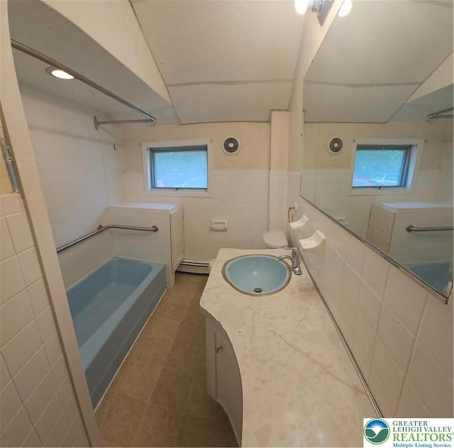 455 W Church St, Slatington Boro, PA 18080 - full bathroom featuring tile walls, vanity, a baseboard heating unit, and bathtub / shower combination