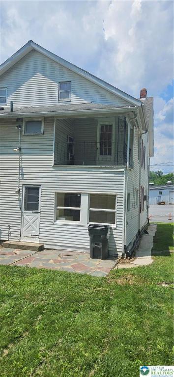 455 W Church St, Slatington Boro, PA 18080 - rear view of property featuring a yard, a balcony, a patio area, and a chimney