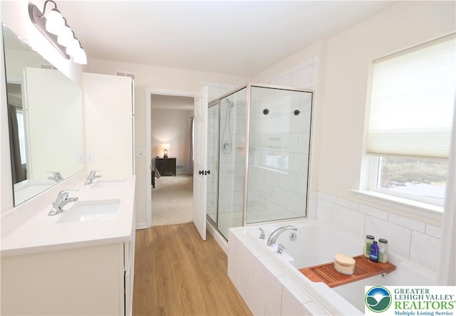 330 Bendelow Ln, Northampton Boro, PA 18067 - bathroom featuring a bath, double vanity, a stall shower, and wood finished floors