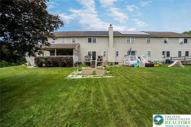 104 Stephanie Dr, Palmer Twp, PA 18045 - rear view of house with a lawn, a sunroom, a wooden deck, and a chimney