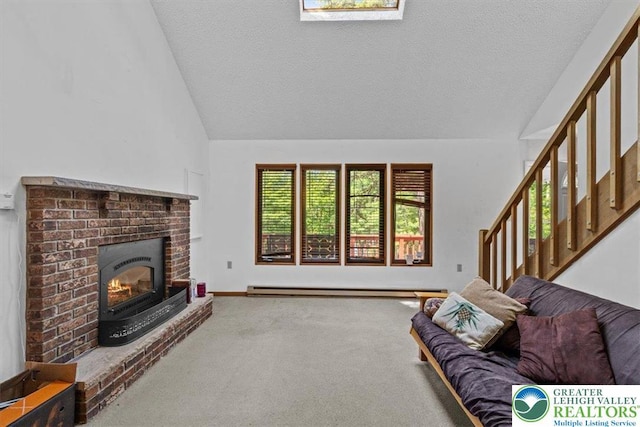 117 Manchester Dr, Lehman Twp, PA 18324 - carpeted living room featuring lofted ceiling, a textured ceiling, baseboard heating, a brick fireplace, and stairway