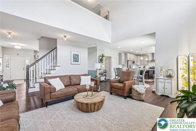 3334 Coventry Dr, Lower Macungie Twp, PA 18062 - living room featuring dark wood-style flooring, stairway, a towering ceiling, and recessed lighting