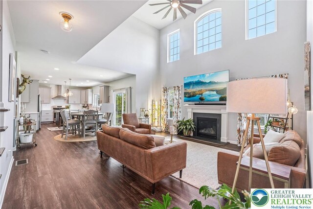 3334 Coventry Dr, Lower Macungie Twp, PA 18062 - living area featuring a ceiling fan, dark wood-style floors, a glass covered fireplace, a towering ceiling, and recessed lighting