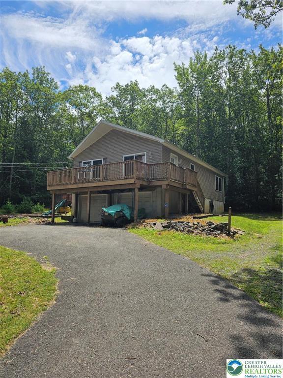 178 Sparrow Ln, Penn Forest Twp, PA 18229 - view of front of house featuring stairs, a deck, asphalt driveway, and an attached garage