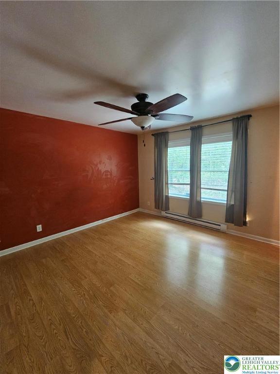 178 Sparrow Ln, Penn Forest Twp, PA 18229 - spare room with a baseboard heating unit, light wood-style flooring, and a ceiling fan